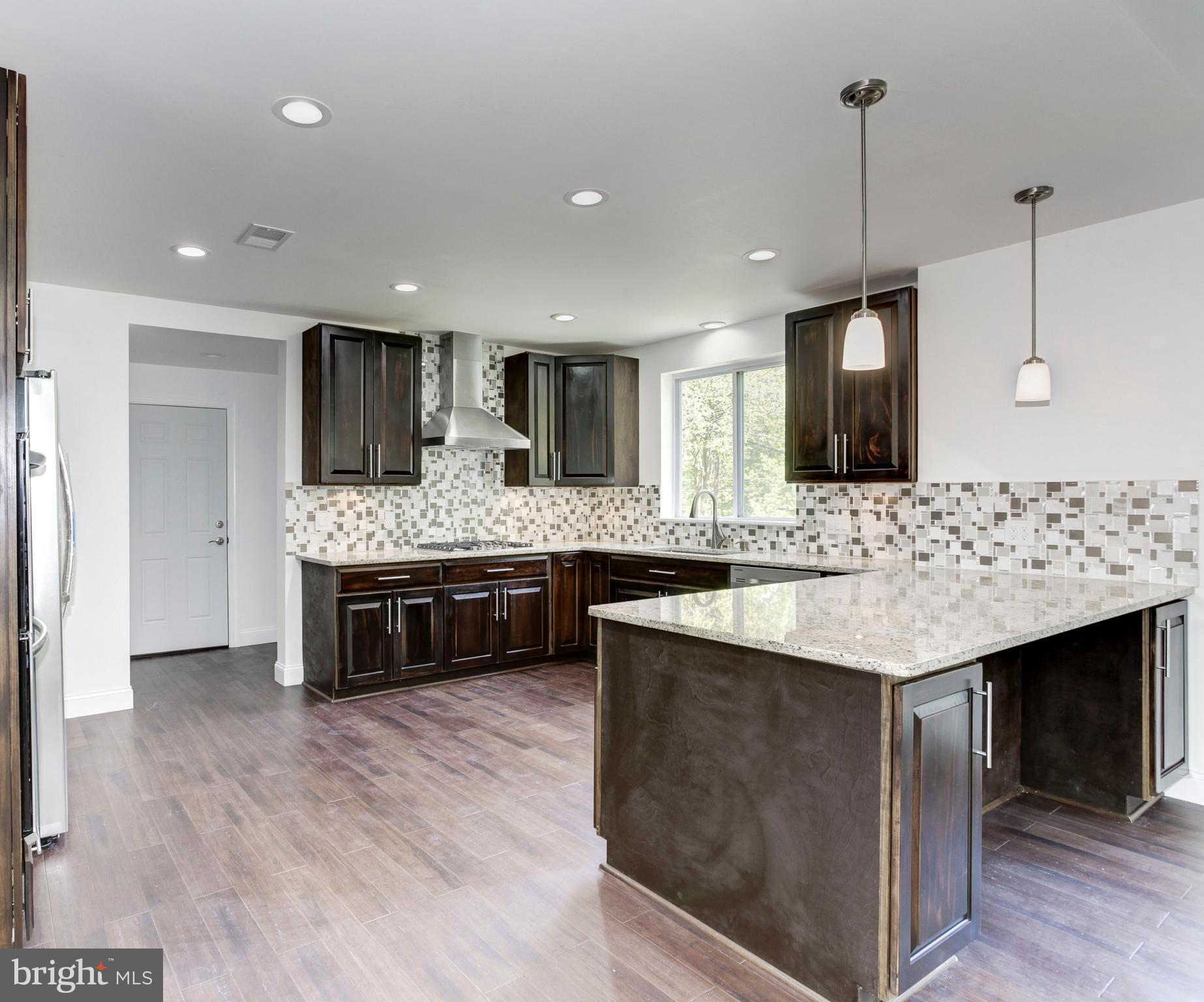 7505 June Street Springfield, VA 22150 - Photo 14 of 29 a large kitchen with a center island and stainless steel appliances