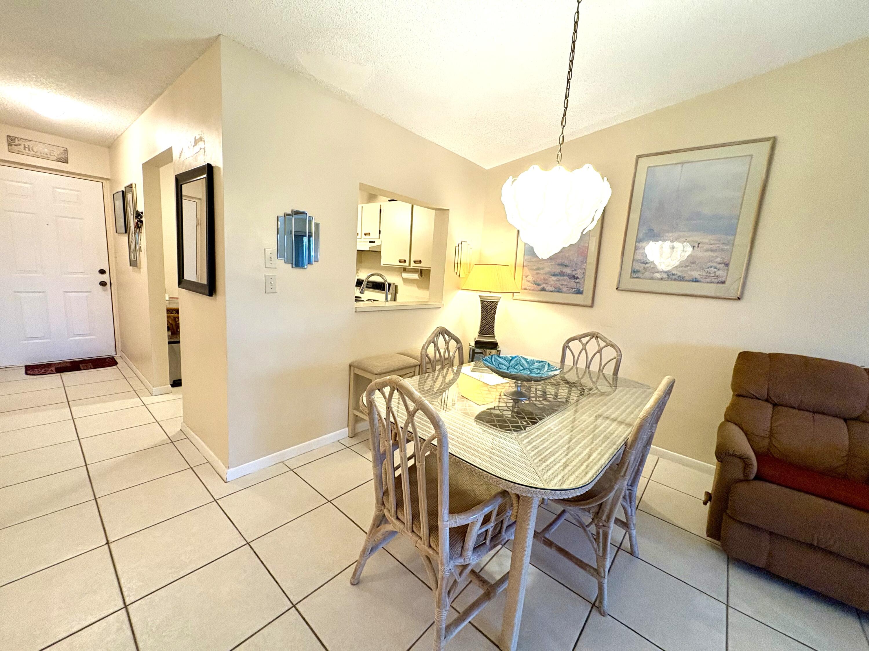 9485 Boca Cove Circle, Unit 709 Boca Raton, FL 33428 - Photo 19 of 42 a view of a dining room with furniture and a chandelier