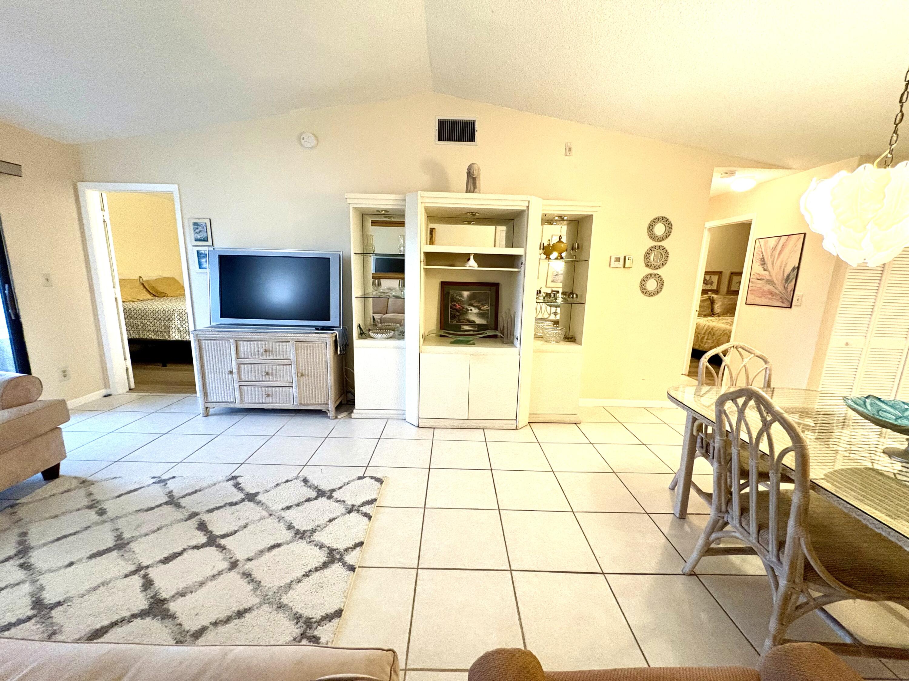 9485 Boca Cove Circle, Unit 709 Boca Raton, FL 33428 - Photo 24 of 42 a living room with furniture and a flat screen tv