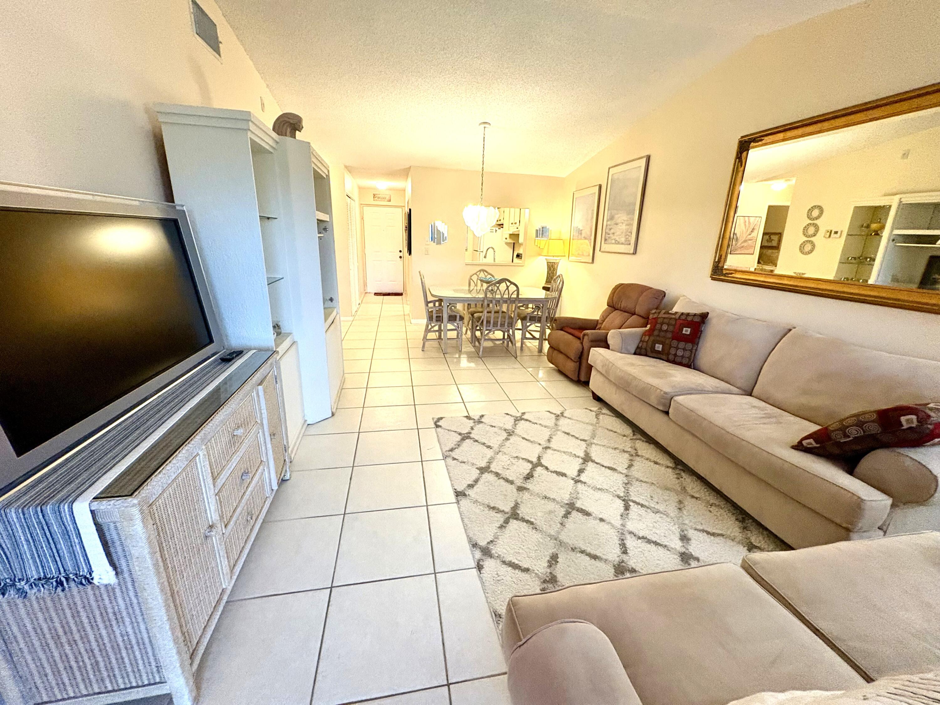 9485 Boca Cove Circle, Unit 709 Boca Raton, FL 33428 - Photo 25 of 42 a living room with furniture and a flat screen tv
