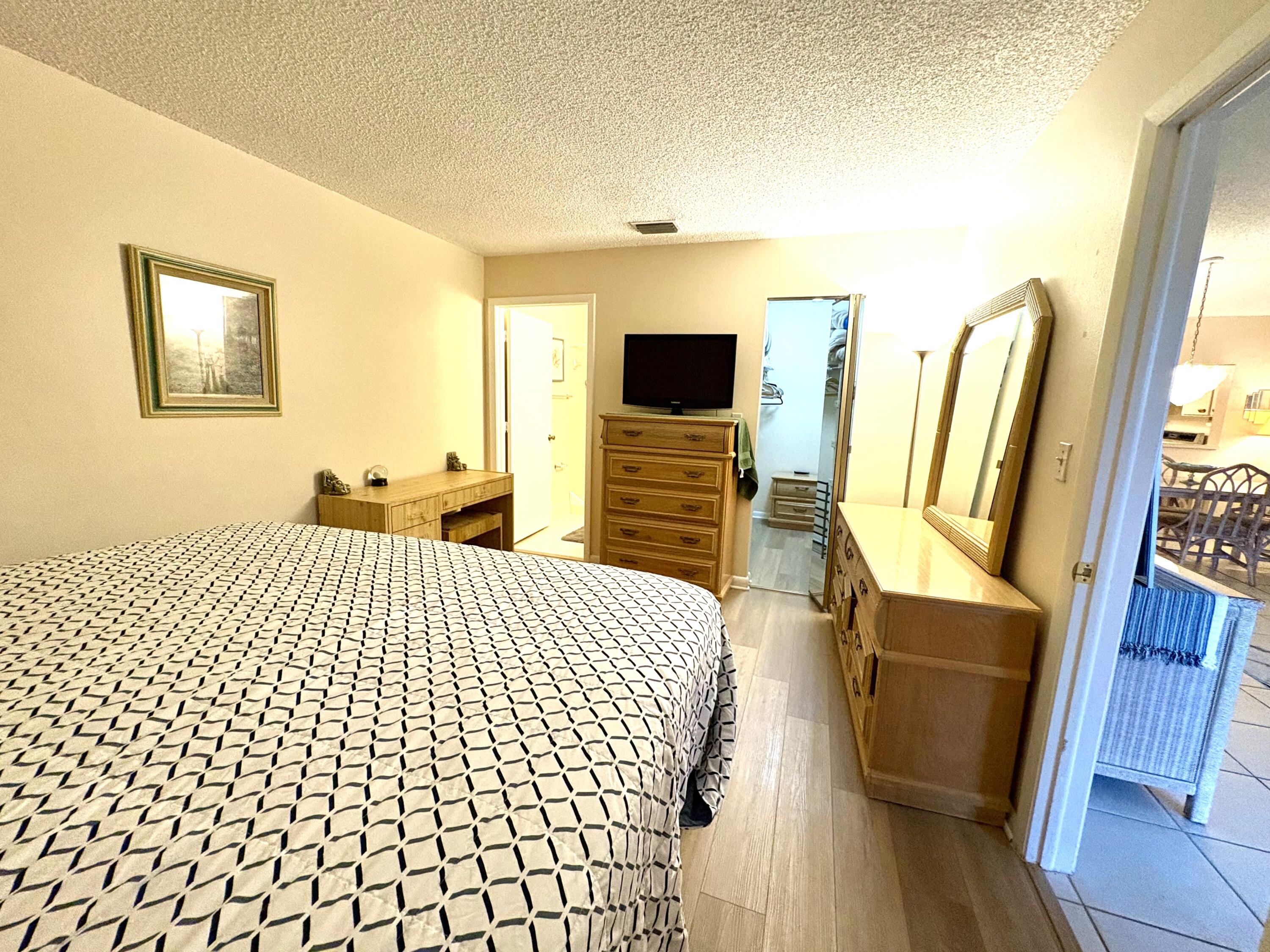 9485 Boca Cove Circle, Unit 709 Boca Raton, FL 33428 - Photo 27 of 42 a bedroom with a bed and wooden floor