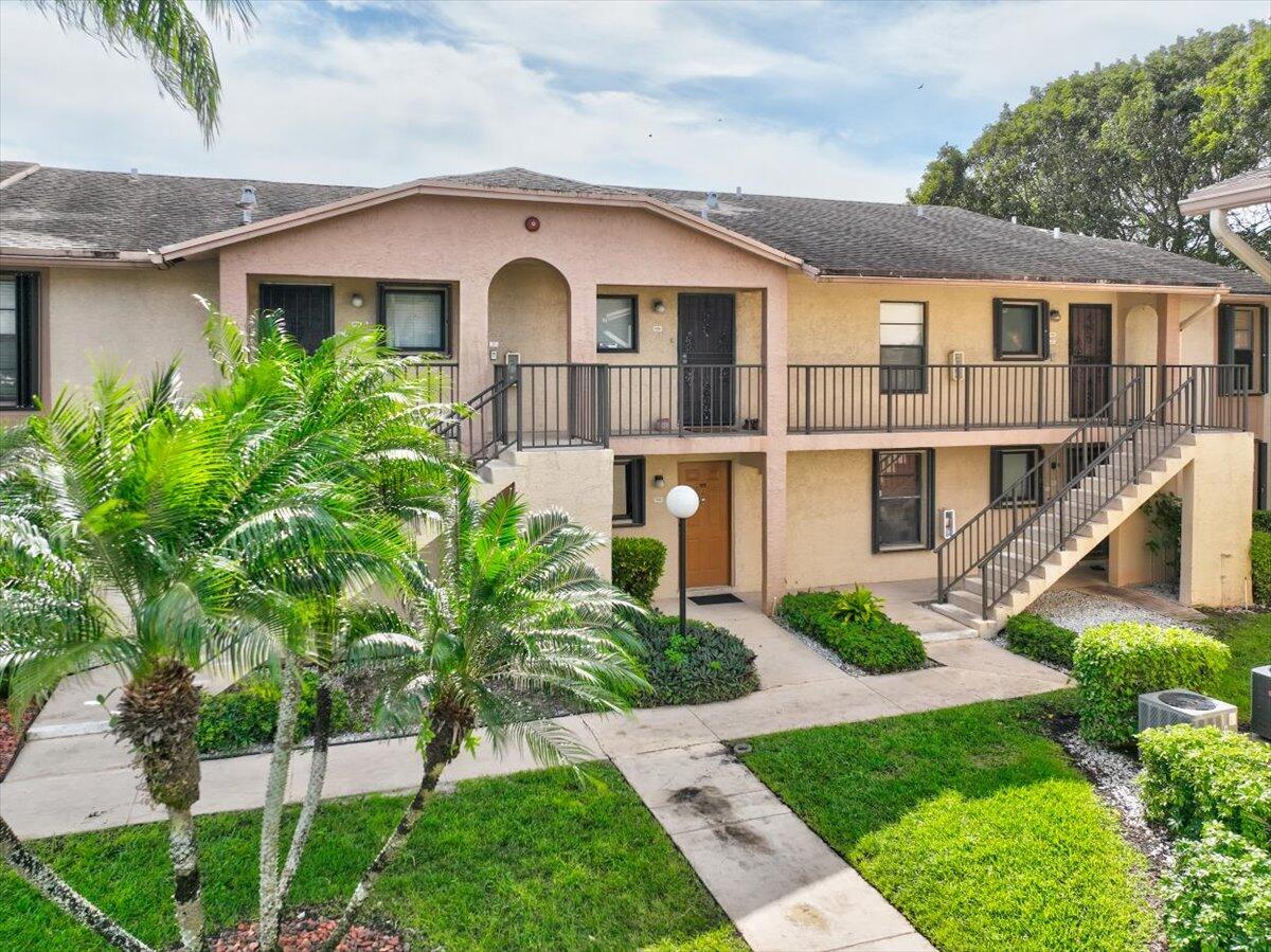 9485 Boca Cove Circle, Unit 709 Boca Raton, FL 33428 - Photo 3 of 42 a front view of a house with a yard