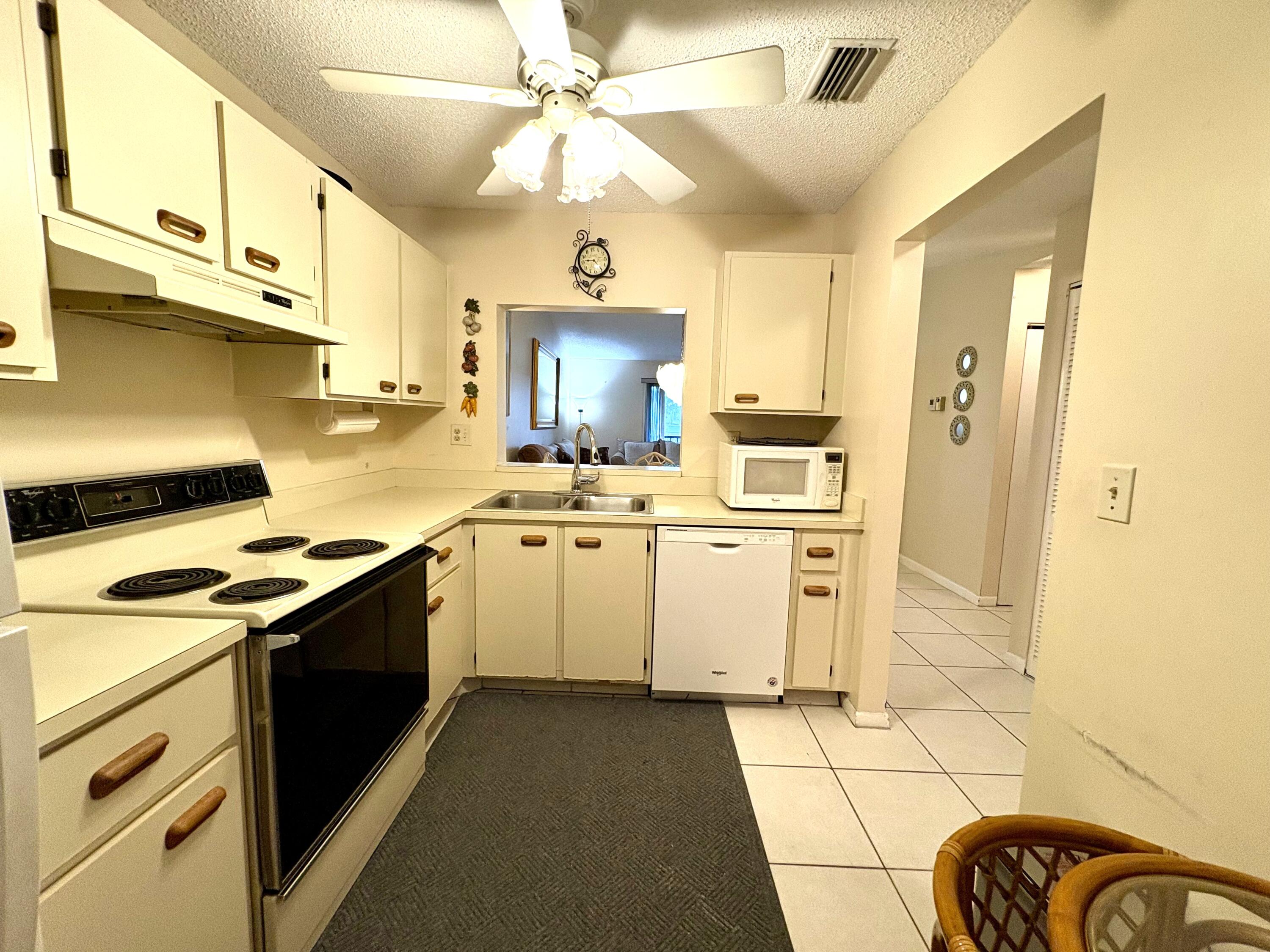 9485 Boca Cove Circle, Unit 709 Boca Raton, FL 33428 - Photo 8 of 42 a kitchen with a stove cabinets and a refrigerator
