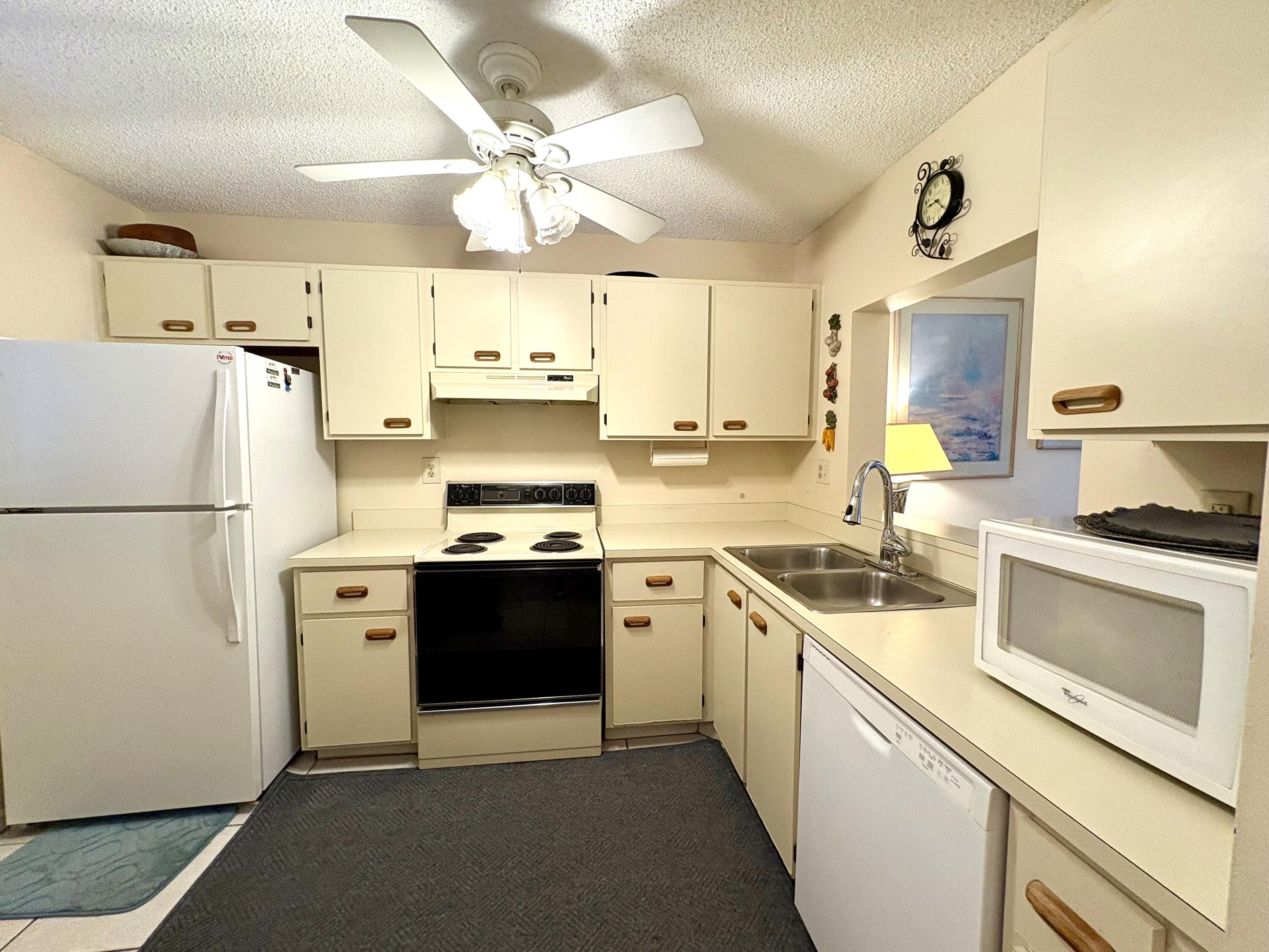 9485 Boca Cove Circle, Unit 709 Boca Raton, FL 33428 - Photo 9 of 42 a kitchen with stainless steel appliances granite countertop a refrigerator a stove a sink and white cabinets