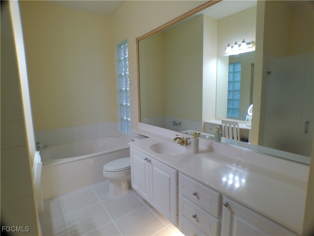 4780 Martinique Way Naples, FL 34119 - Photo 27 of 49 a bathroom with a double vanity sink toilet and shower