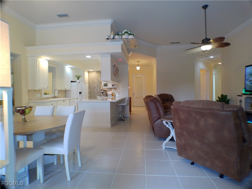 4780 Martinique Way Naples, FL 34119 - Photo 31 of 49 a dining room with furniture and a chandelier