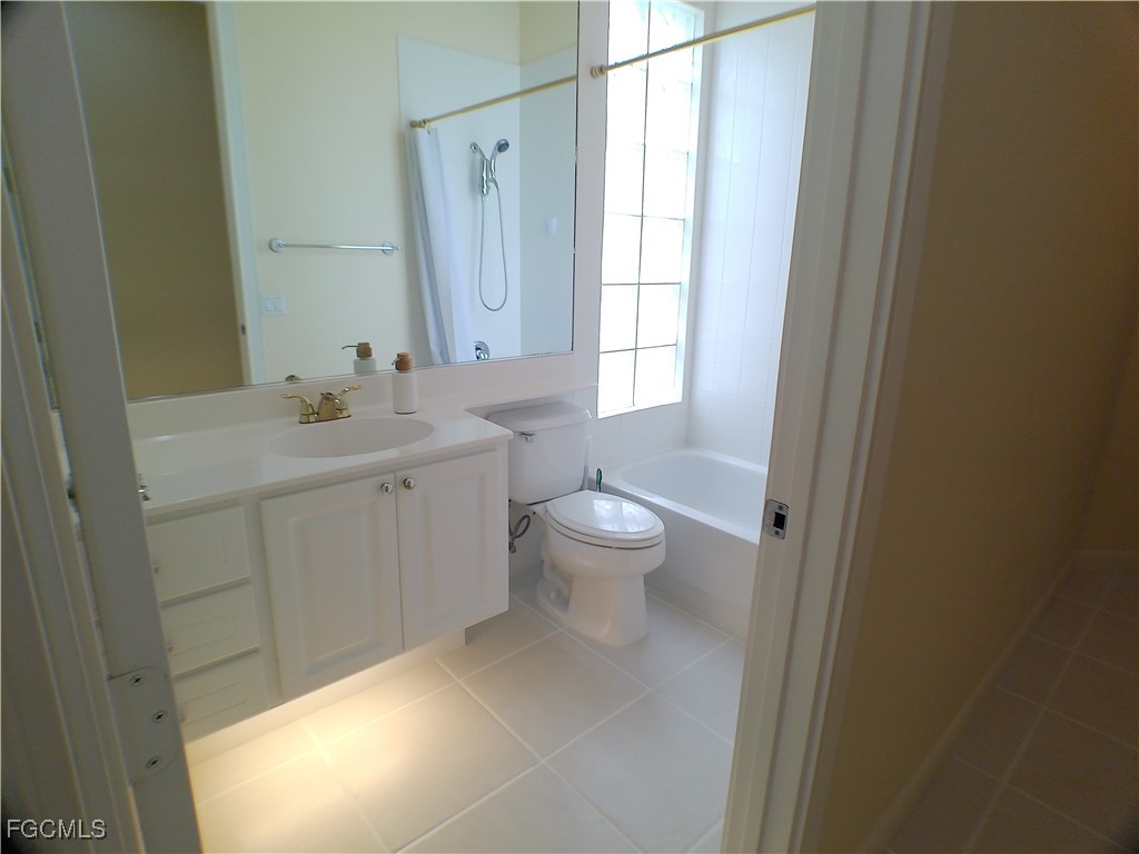 4780 Martinique Way Naples, FL 34119 - Photo 34 of 49 a spacious bathroom with a granite countertop sink a toilet and a mirror