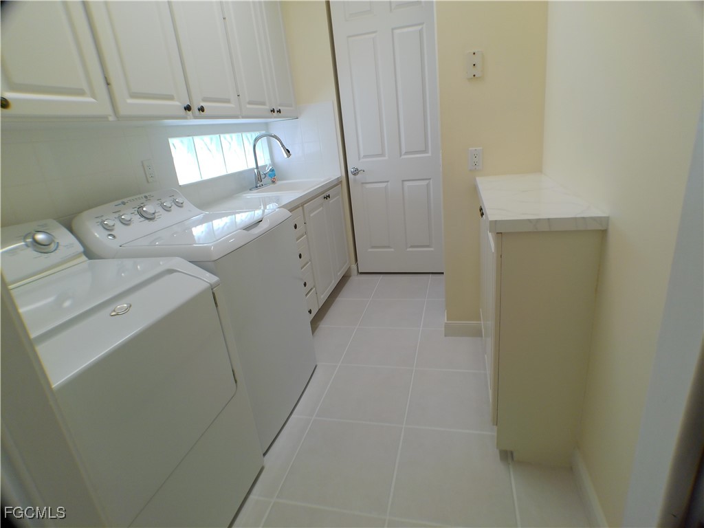 4780 Martinique Way Naples, FL 34119 - Photo 35 of 49 a utility room with cabinets washer and dryer