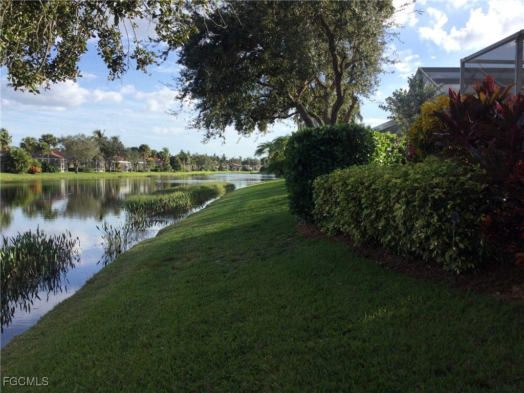4780 Martinique Way Naples, FL 34119 - Photo 38 of 49 a view of a lake with a yard
