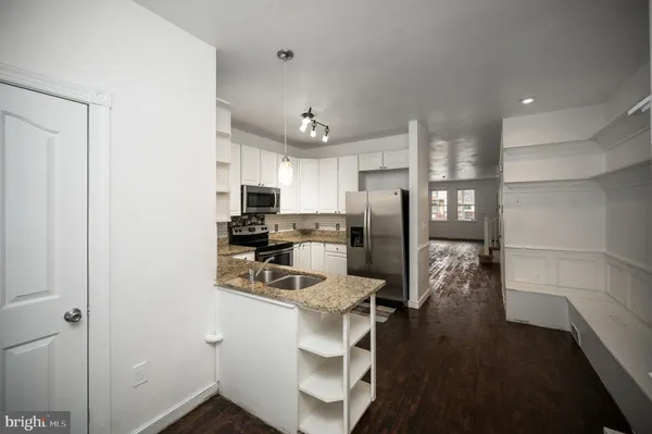 a kitchen with granite countertop a sink and cabinets