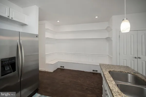 a kitchen with granite countertop a refrigerator and a sink