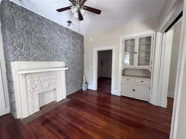 a view of an empty room with a fireplace and a window