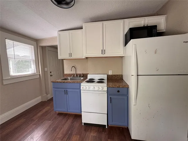 a kitchen with a stove top oven and a refrigerator