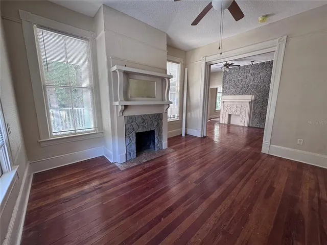 a view of empty room with wooden floor and fireplace