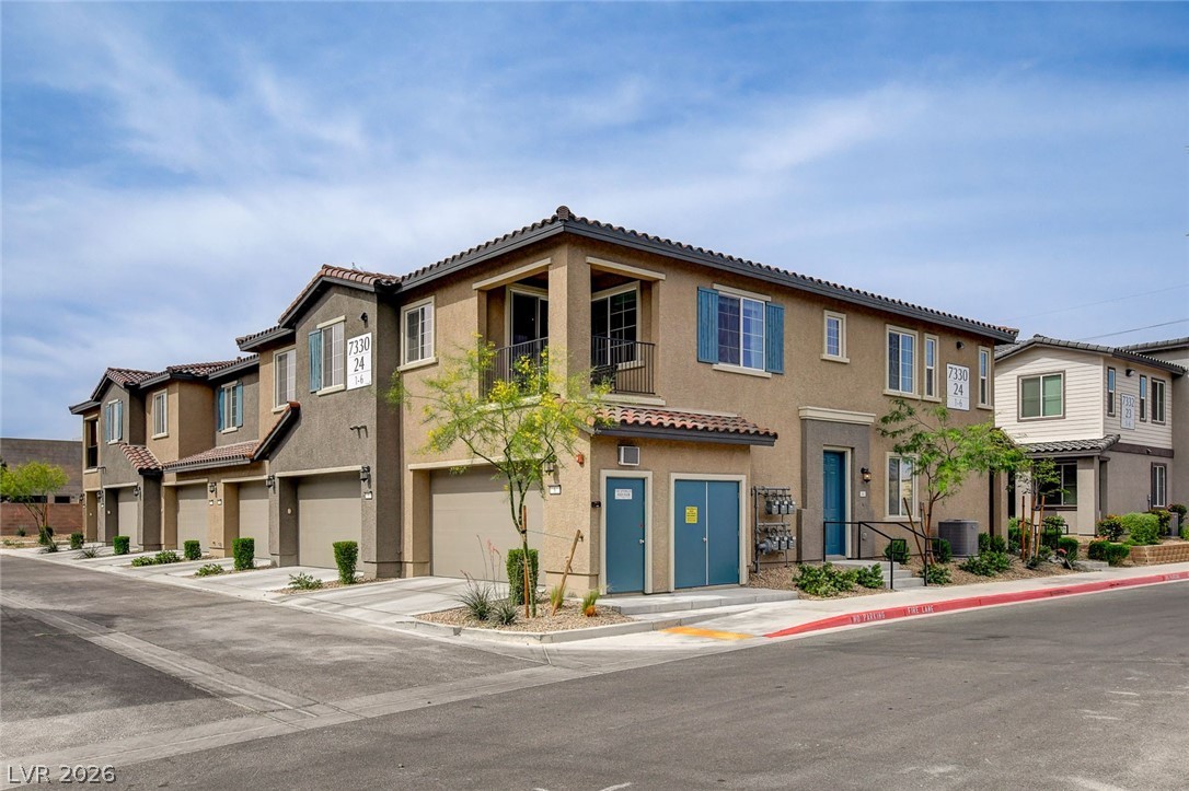 7330 North Decatur Boulevard, Unit 6 North Las Vegas, NV 89084 - Photo 16 of 42 Contemporary multi-level townhomes present a clean facade with integrated garages and balconies.