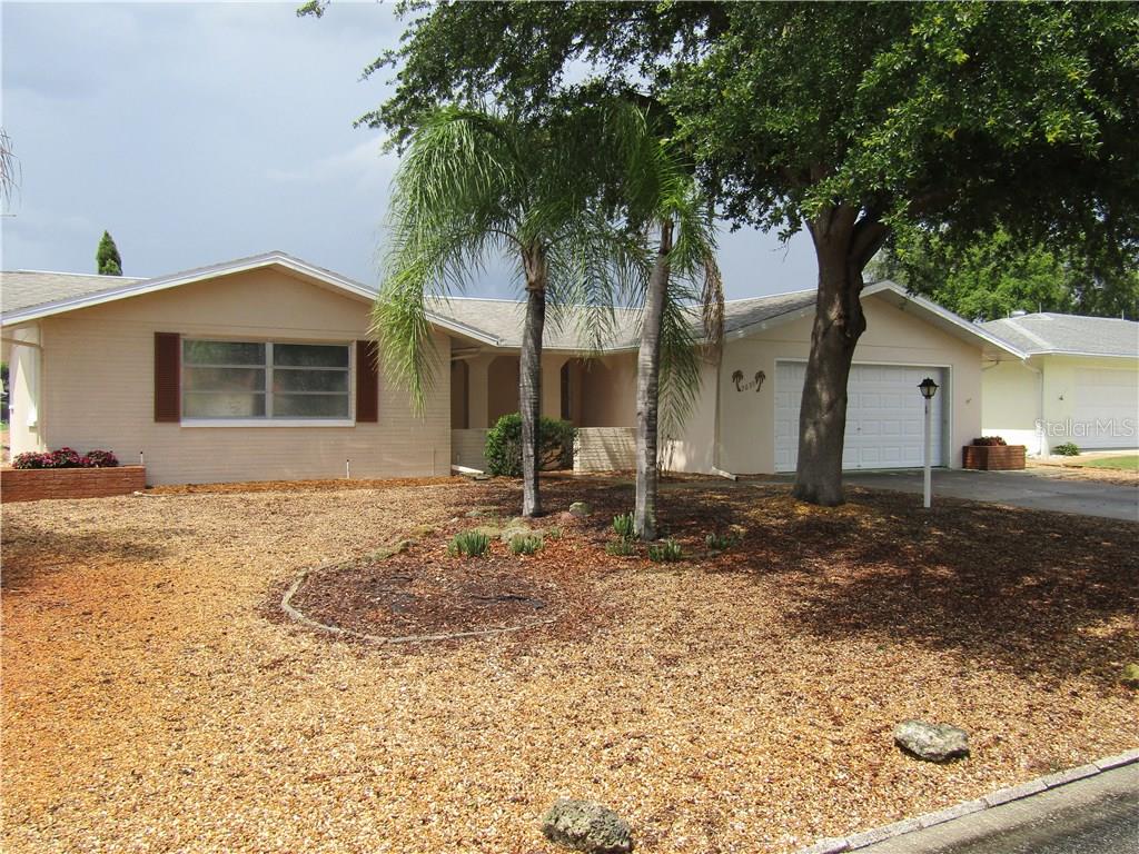 7635 Rosewood Drive Port Richey, FL 34668 - Photo 1 of 1 a front view of a house with a yard and garage