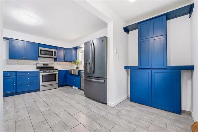 a kitchen with stainless steel appliances granite countertop a refrigerator stove and a sink with wooden cabinets