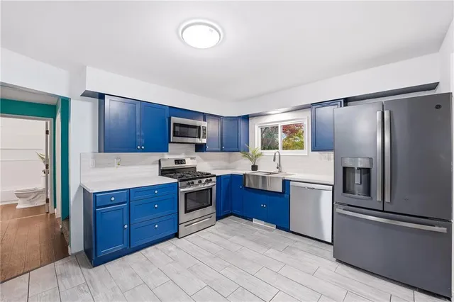 a kitchen with stainless steel appliances granite countertop a refrigerator stove top oven and sink