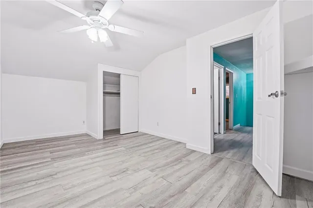 a view of an empty room with closet and a chandelier fan