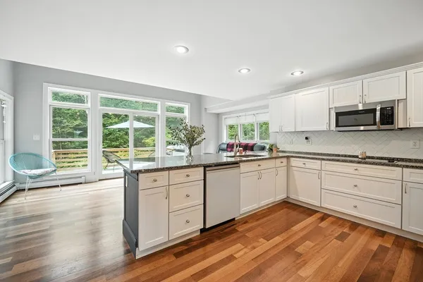 a kitchen with stainless steel appliances granite countertop a stove a sink and a microwave