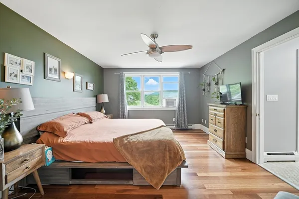 a bedroom with a bed and wooden floor