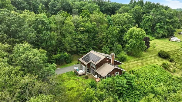 an aerial view of residential houses with outdoor space and trees