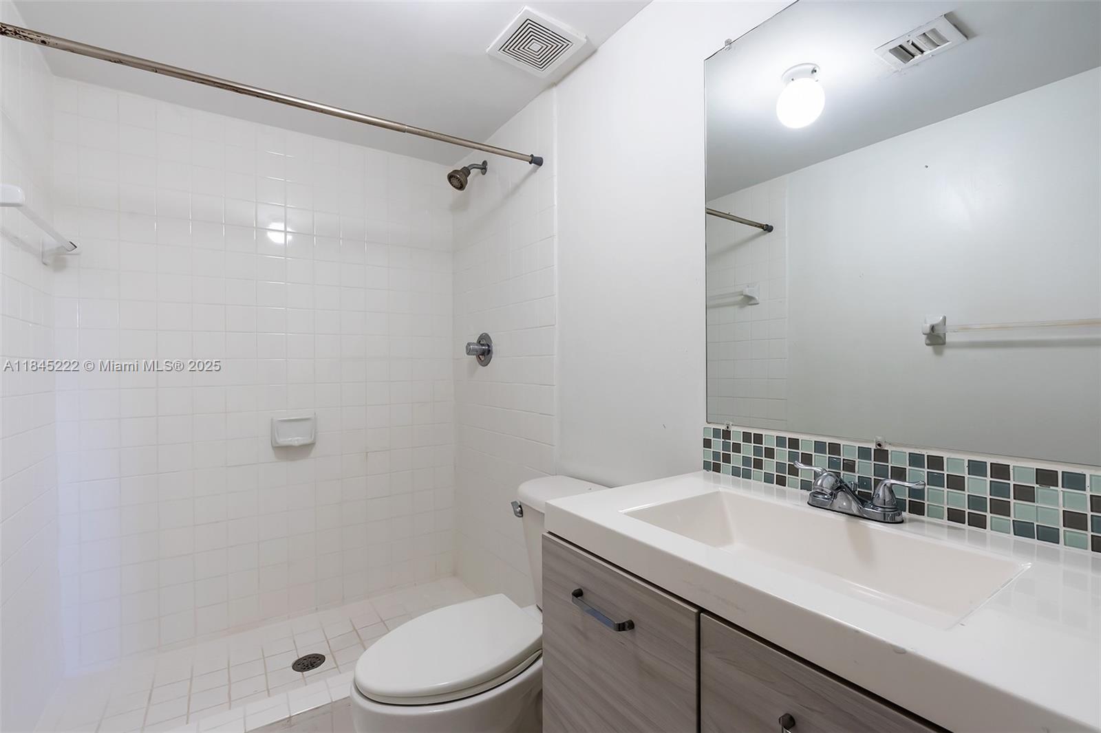 1060 Northwest 7th Street, Unit 101 Miami, FL 33136 - Photo 12 of 20 a bathroom with a sink a toilet and shower