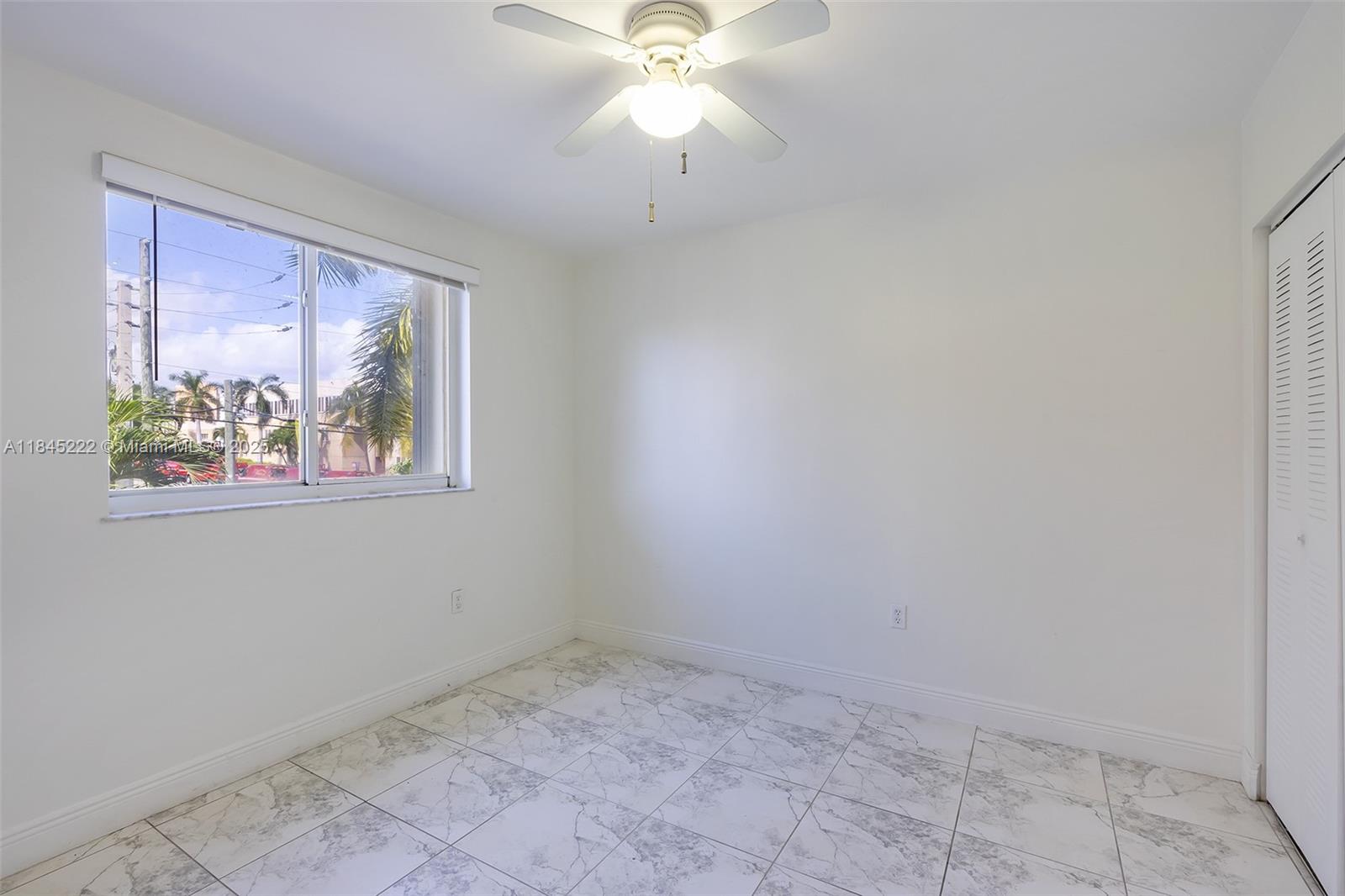 1060 Northwest 7th Street, Unit 101 Miami, FL 33136 - Photo 14 of 20 an empty room with windows and fan