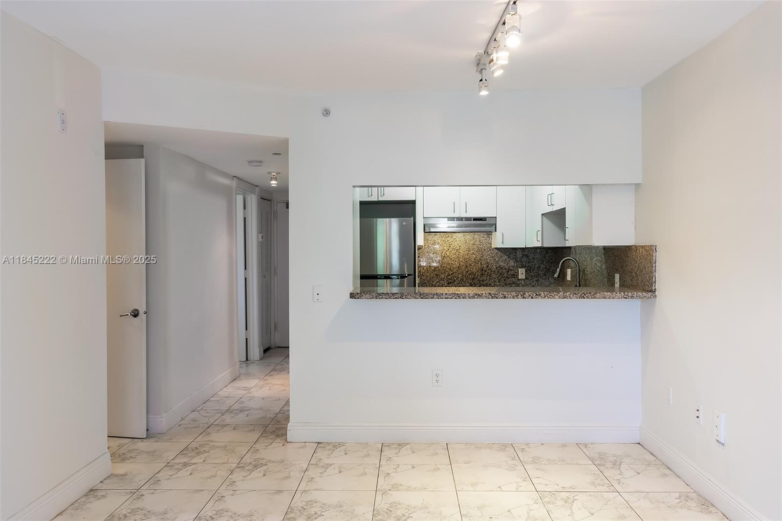 1060 Northwest 7th Street, Unit 101 Miami, FL 33136 - Photo 9 of 20 a large white kitchen with a sink stainless steel appliances and cabinets