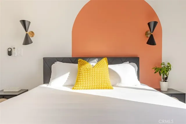 a bedroom with a bed and a potted plant