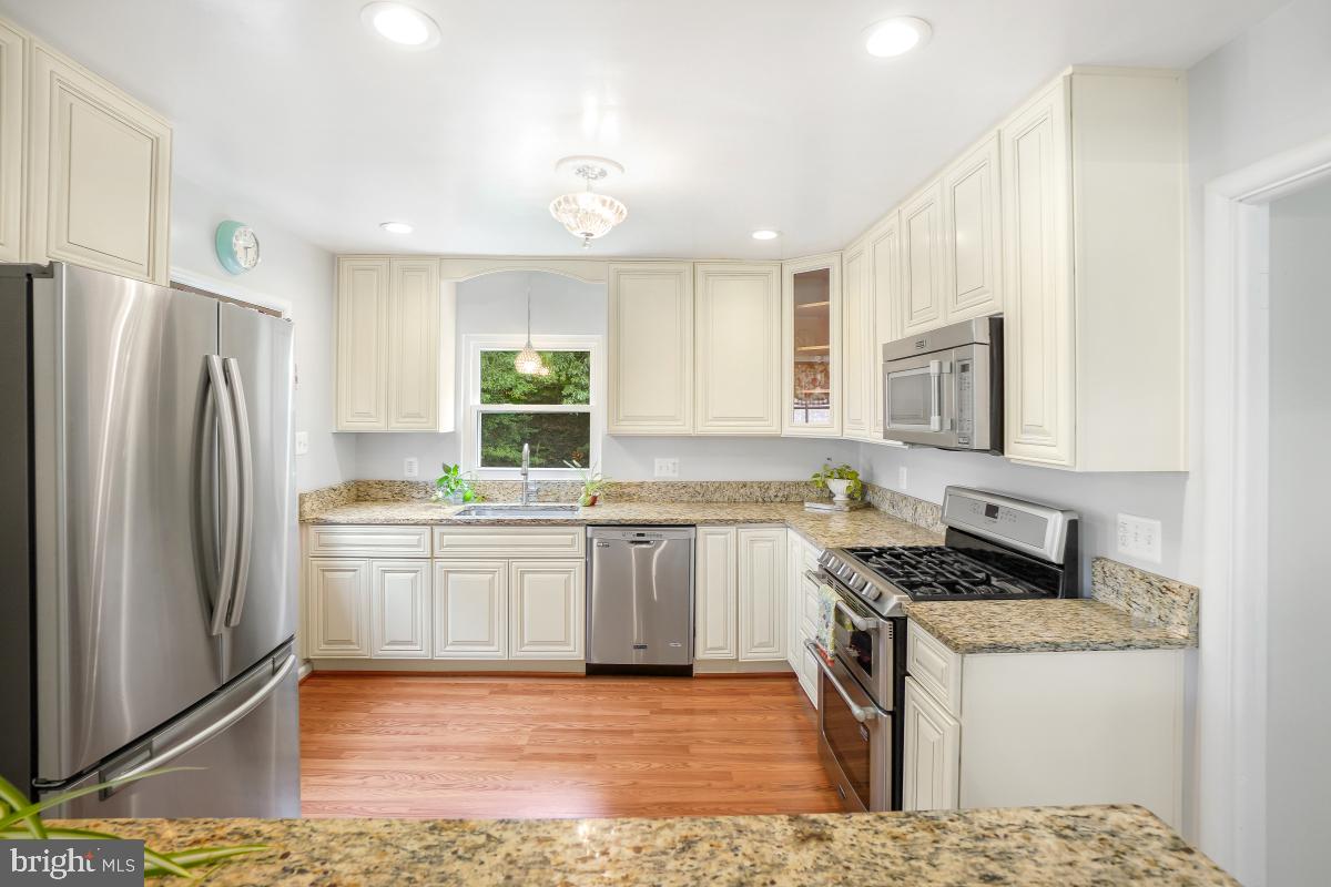 6013 Hawthorne Street Cheverly, MD 20785 - Photo 11 of 30 a kitchen with stainless steel appliances granite countertop a stove a sink and a refrigerator
