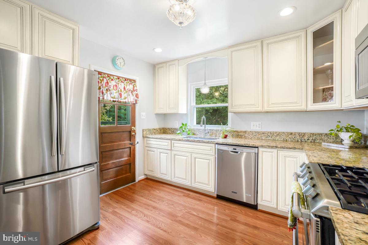 6013 Hawthorne Street Cheverly, MD 20785 - Photo 12 of 30 a kitchen with granite countertop stainless steel appliances a refrigerator cabinets and wooden floor