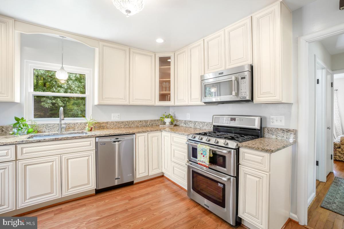 6013 Hawthorne Street Cheverly, MD 20785 - Photo 13 of 30 a kitchen with stainless steel appliances granite countertop a stove a sink and a microwave
