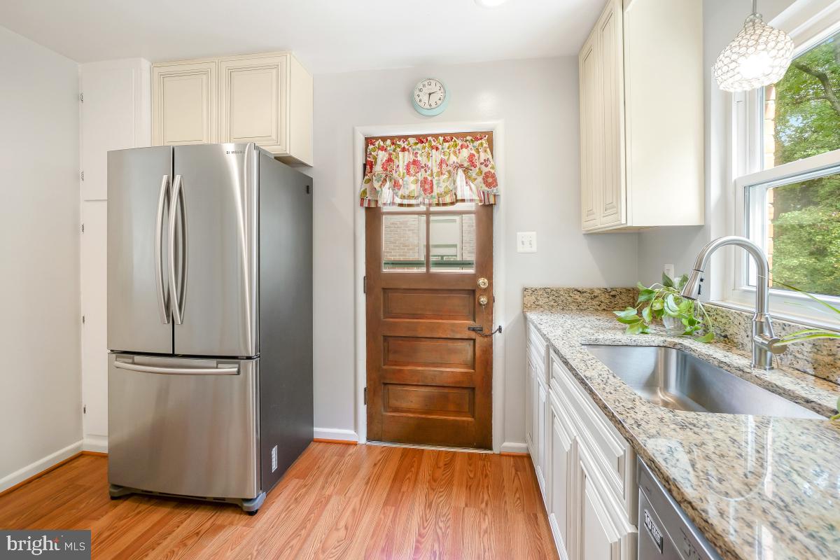 6013 Hawthorne Street Cheverly, MD 20785 - Photo 15 of 30 a kitchen with granite countertop stainless steel appliances a refrigerator sink and wooden floor