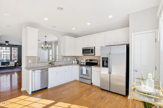 a kitchen with granite countertop a refrigerator and a stove top oven