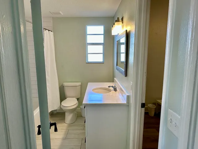 a bathroom with sink and mirror with toilet