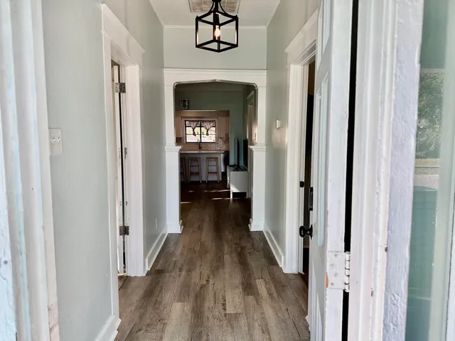 a view of a hallway with wooden floor and a livingroom view