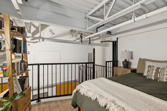 a bedroom with a bed and wooden floor