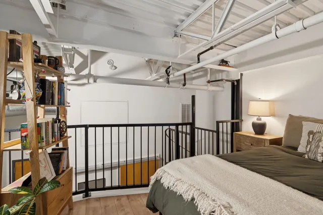 a bedroom with a bed with the view of hallway