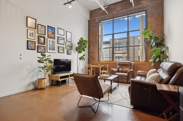 a living room with furniture a fireplace and a potted plant