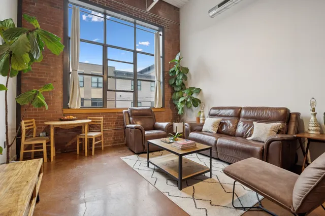 a living room with furniture and a potted plant