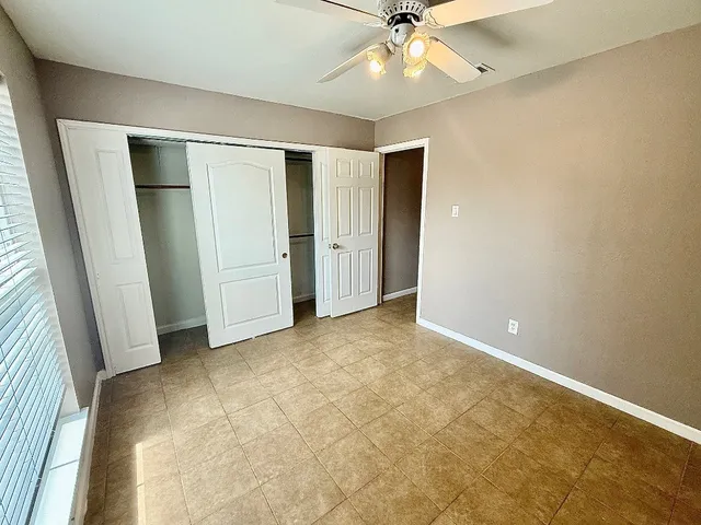 an empty room with fan and entrance