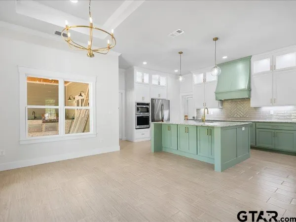 a kitchen with kitchen island a sink and a refrigerator