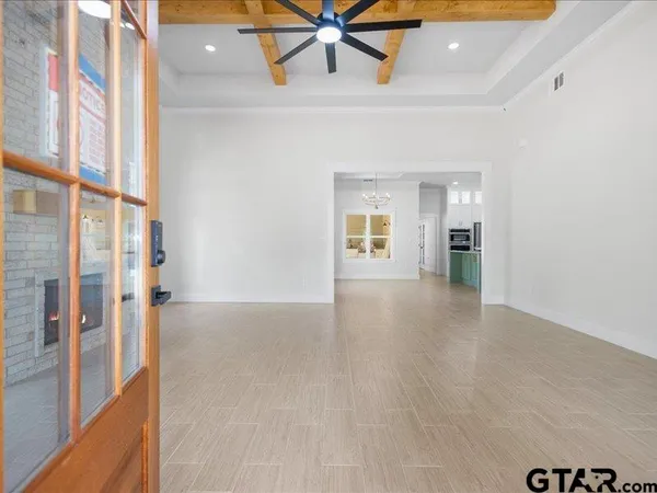 a view of an empty room with window and wooden floor