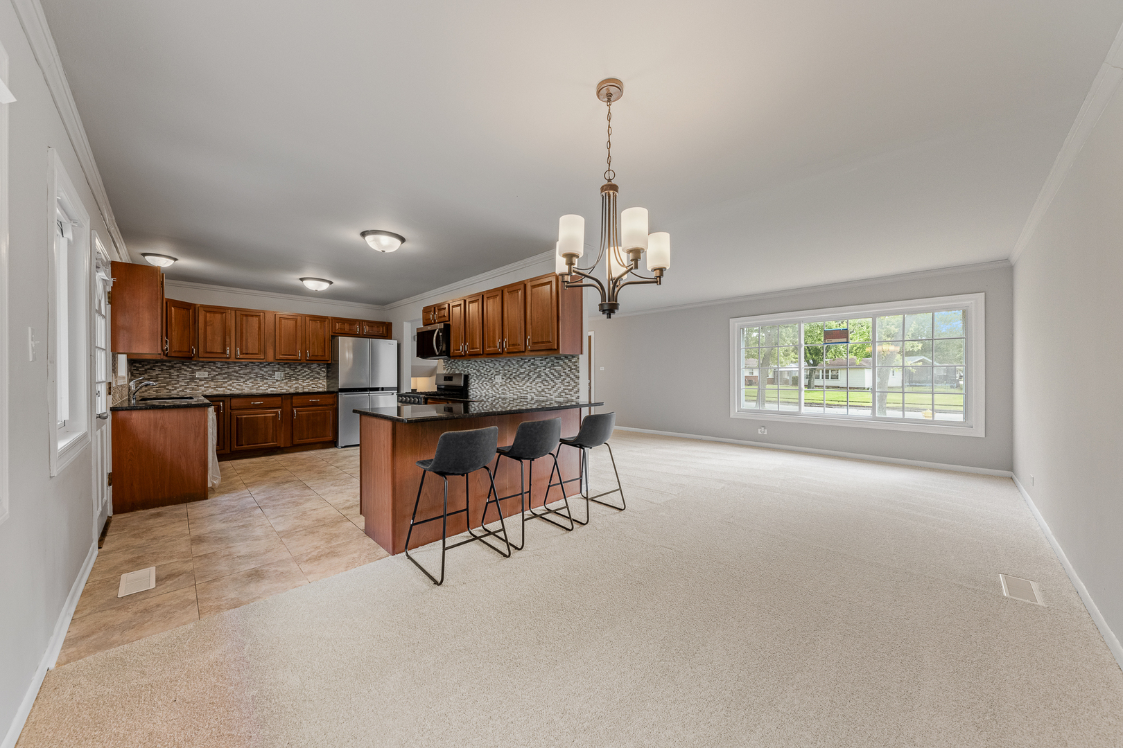 303 Springfield Street Park Forest, IL 60466 - Photo 3 of 16 a open kitchen with kitchen island a stove a table and chairs in it
