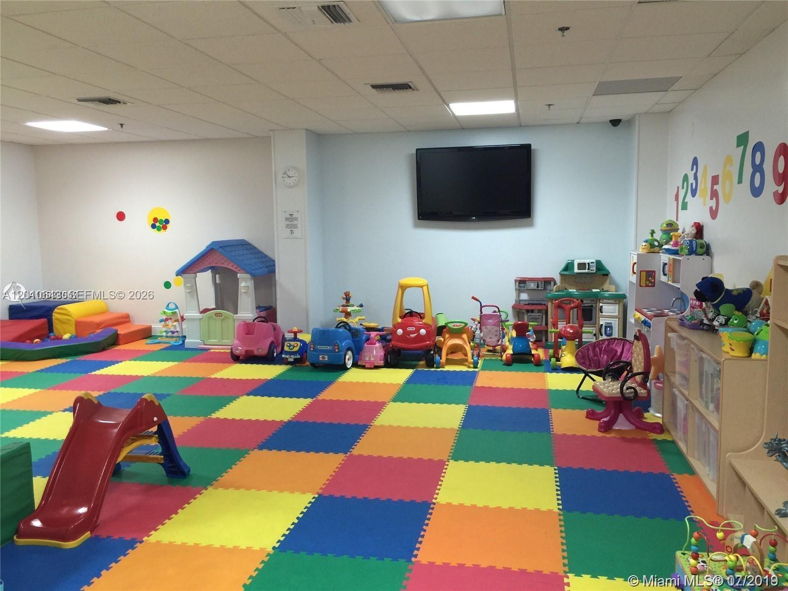540 Brickell Key Drive, Unit PH1812 Miami, FL 33131 - Photo 25 of 29 a room with lots of baby toys and flat tv screen