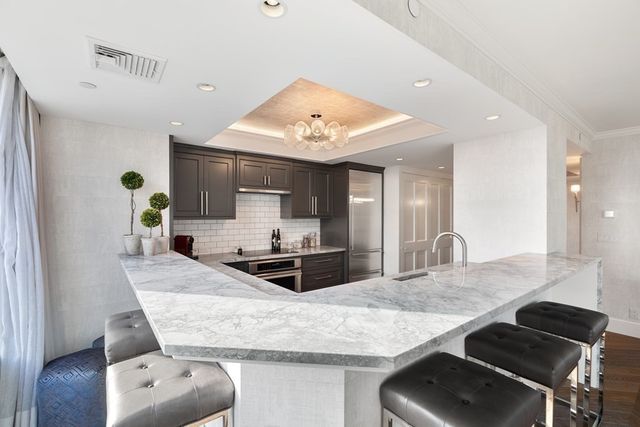 a kitchen with granite countertop a stove and white cabinets