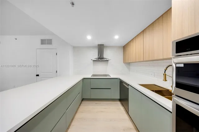 a kitchen with stainless steel appliances a refrigerator sink and cabinets