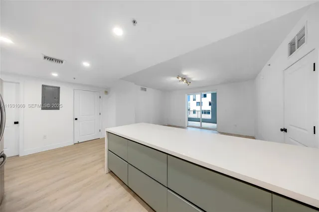 a large white kitchen with stainless steel appliances