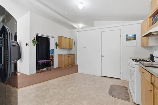 a view of a kitchen with fridge and wooden floor